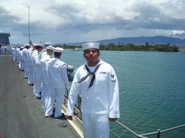 Ed DeJesus in dress whites manning the rails aboard USS Kitty Hawk as the carrier enters Pearl Harbor